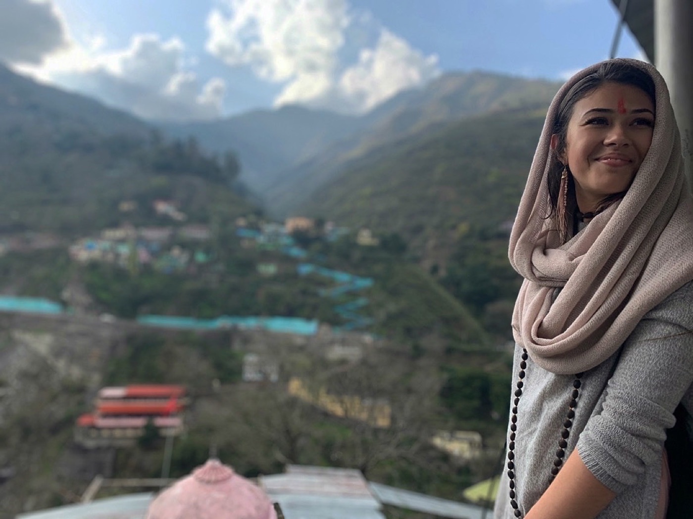 Brittany in India, smiling with mountains behind her