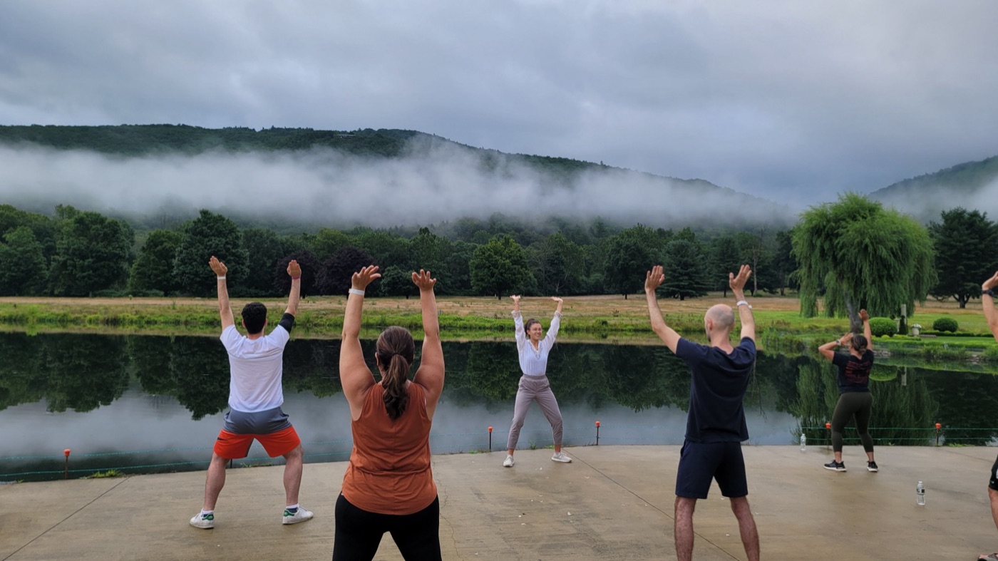 Brittany leading an outdoor movement class by a misty lake