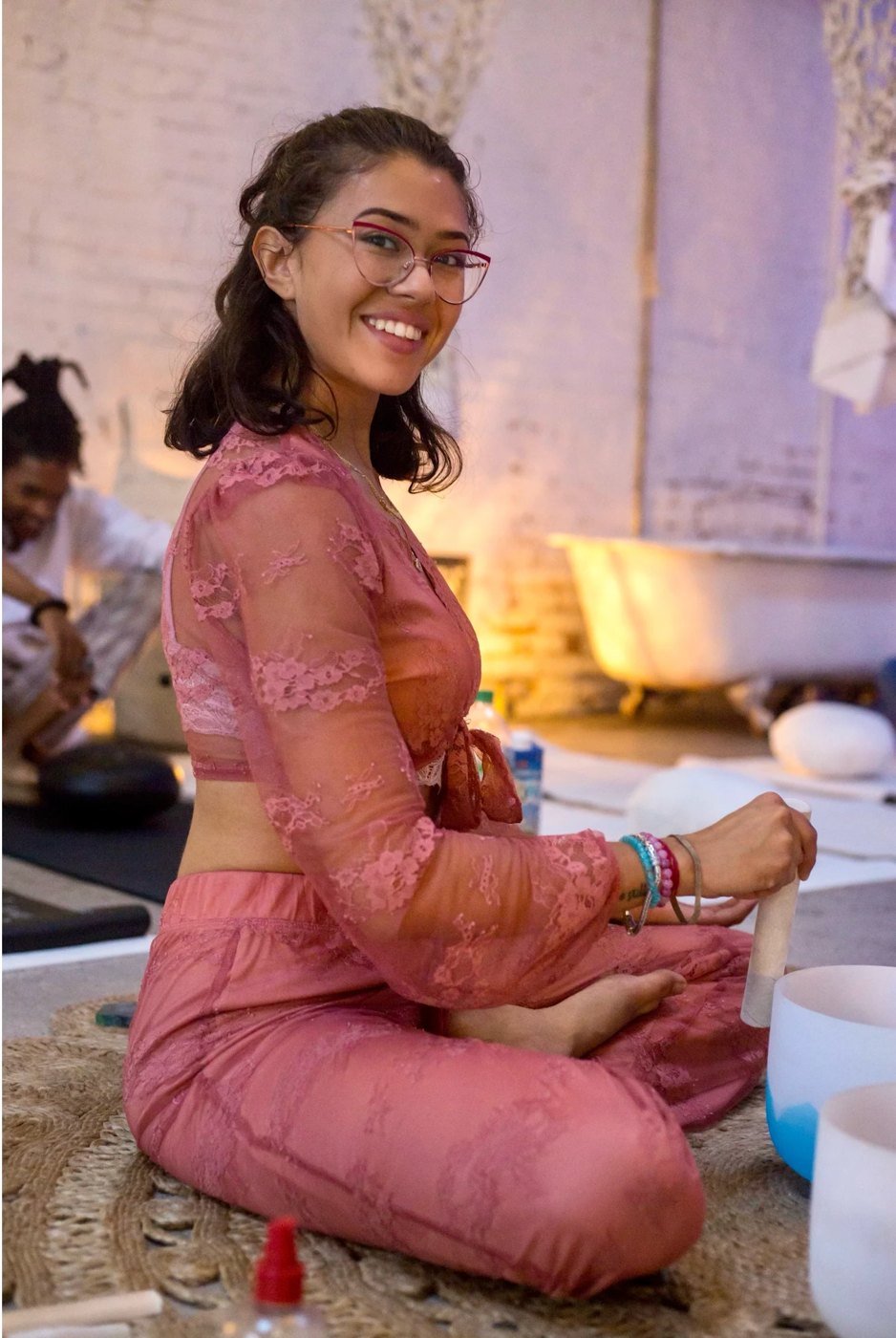 Brittany smiling while leading a sound bath with crystal bowls