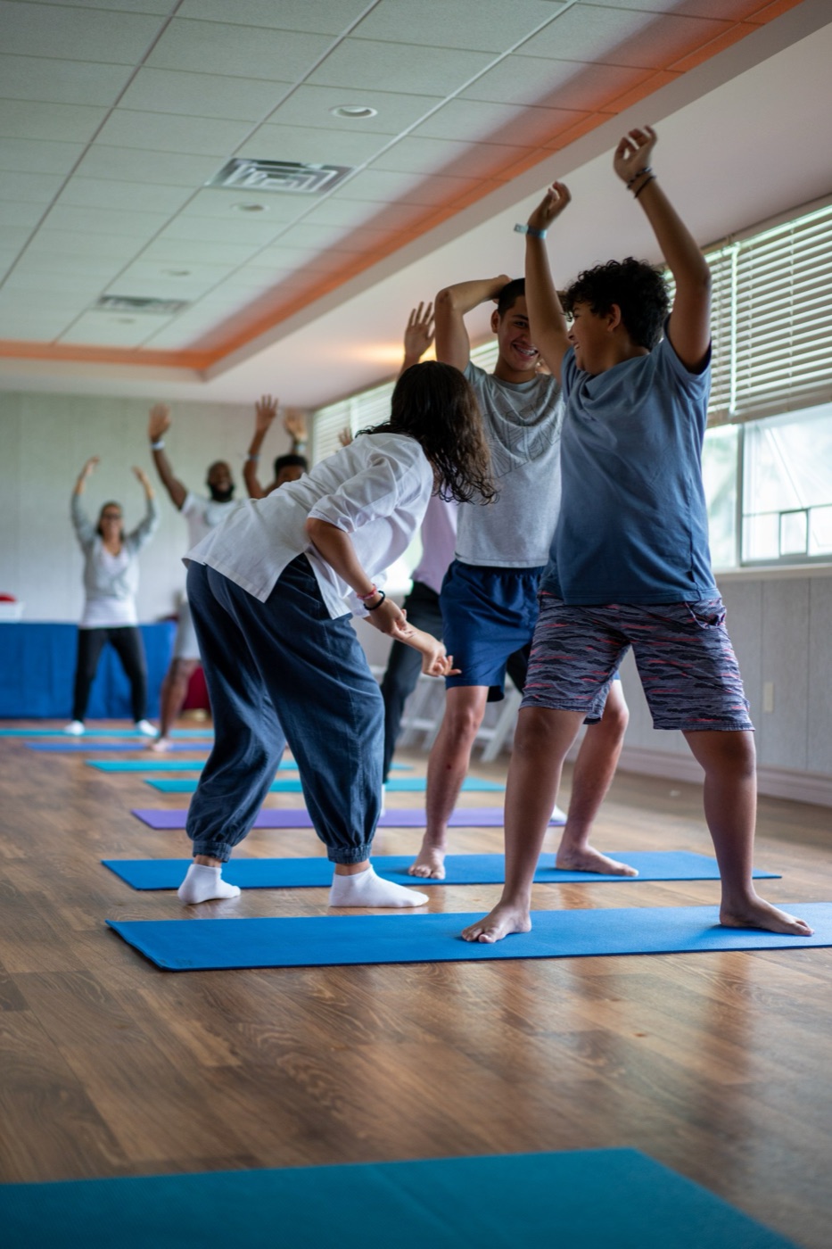 Brittany guiding young students through movement on yoga mats