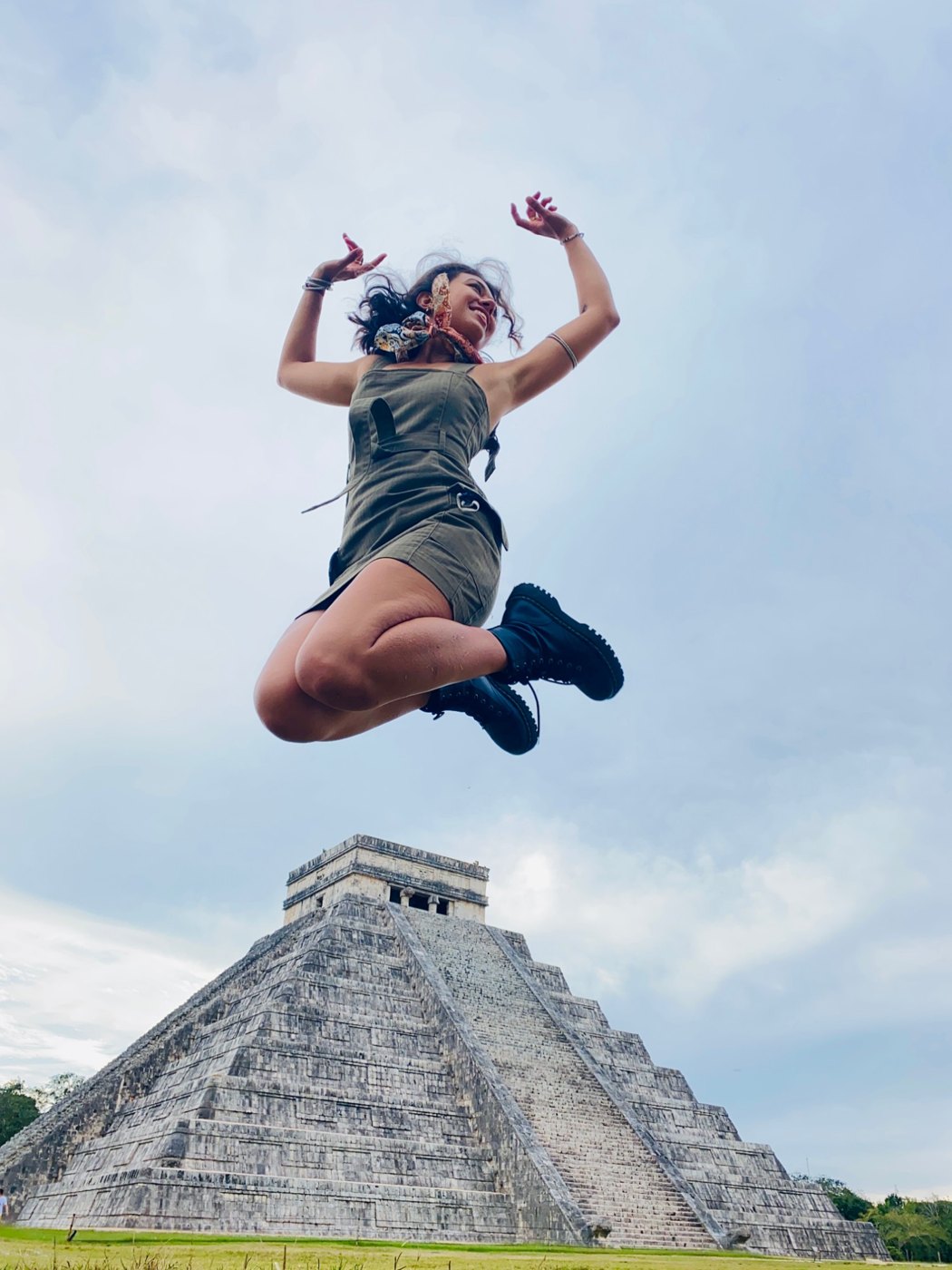 Brittany jumping joyfully in front of the pyramid at Chichén Itzá